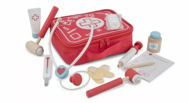 Red toy doctor kit with a zippered bag, stethoscope, thermometer, syringe, medicine bottles, bandages, reflex hammer, tube, and a prescription pad, arranged on a white background.