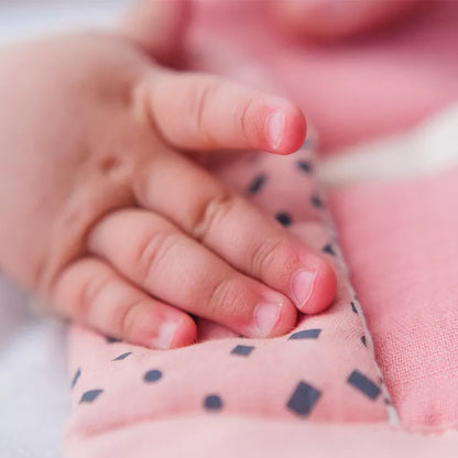 A close up of a person holding an Organic Activity Baby Toy Mouse.