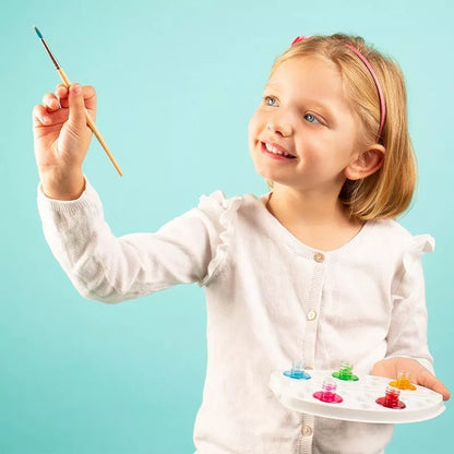 A little girl holding a Sentosphere Aquarellum Junior In The Air paintbrush and palette.