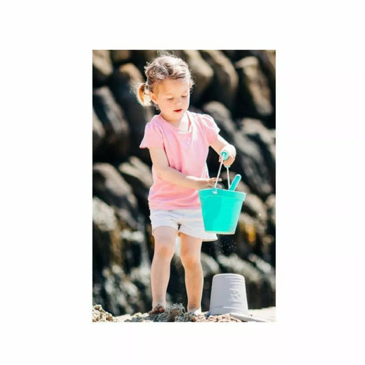 A little girl playing with a Bigjigs Eggshell Eco Bucket & Spade.