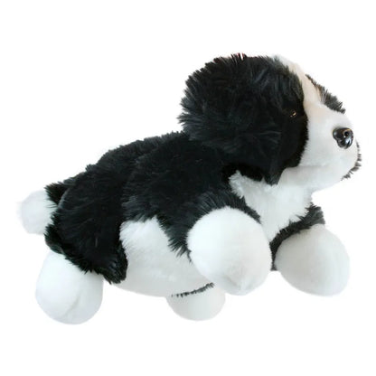 The Puppet Company Full-bodied Hand Puppet Border Collie is a soft, black and white plush toy dog lying on its stomach with outstretched legs—ideal for imaginative play.