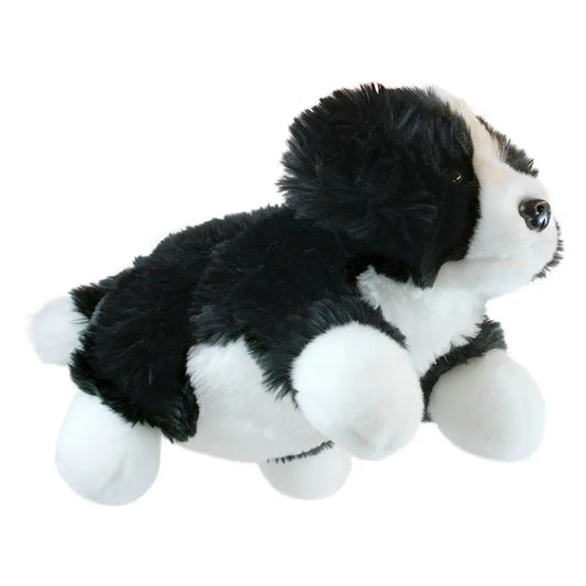 The Puppet Company Full-bodied Hand Puppet Border Collie is a soft, black and white plush toy dog lying on its stomach with outstretched legs—ideal for imaginative play.