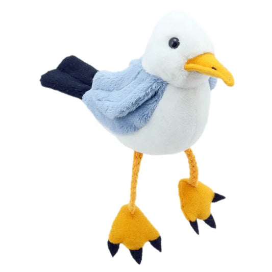 This captivating Puppet Company Seagull Finger Puppet, ideal for storytelling, showcases a blue back, white belly, and orange beak. It has long braided yellow legs and soft flipper-like feet, elegantly standing against a white background.