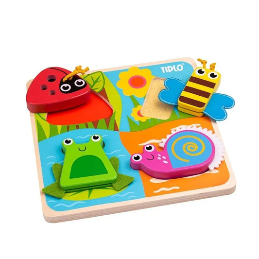 The Touch and Feel Bugs Puzzle features colorful wooden pieces shaped like a ladybug, bee, frog, and snail. With interactive textures and nature-inspired quadrants as the background, the brand name "Tidlo" is visible.