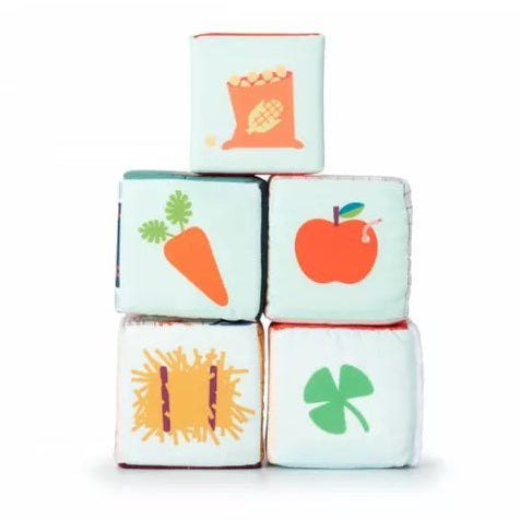 A stack of Lilliputiens Farm House Stacking Cubes with fruits and vegetables on them.